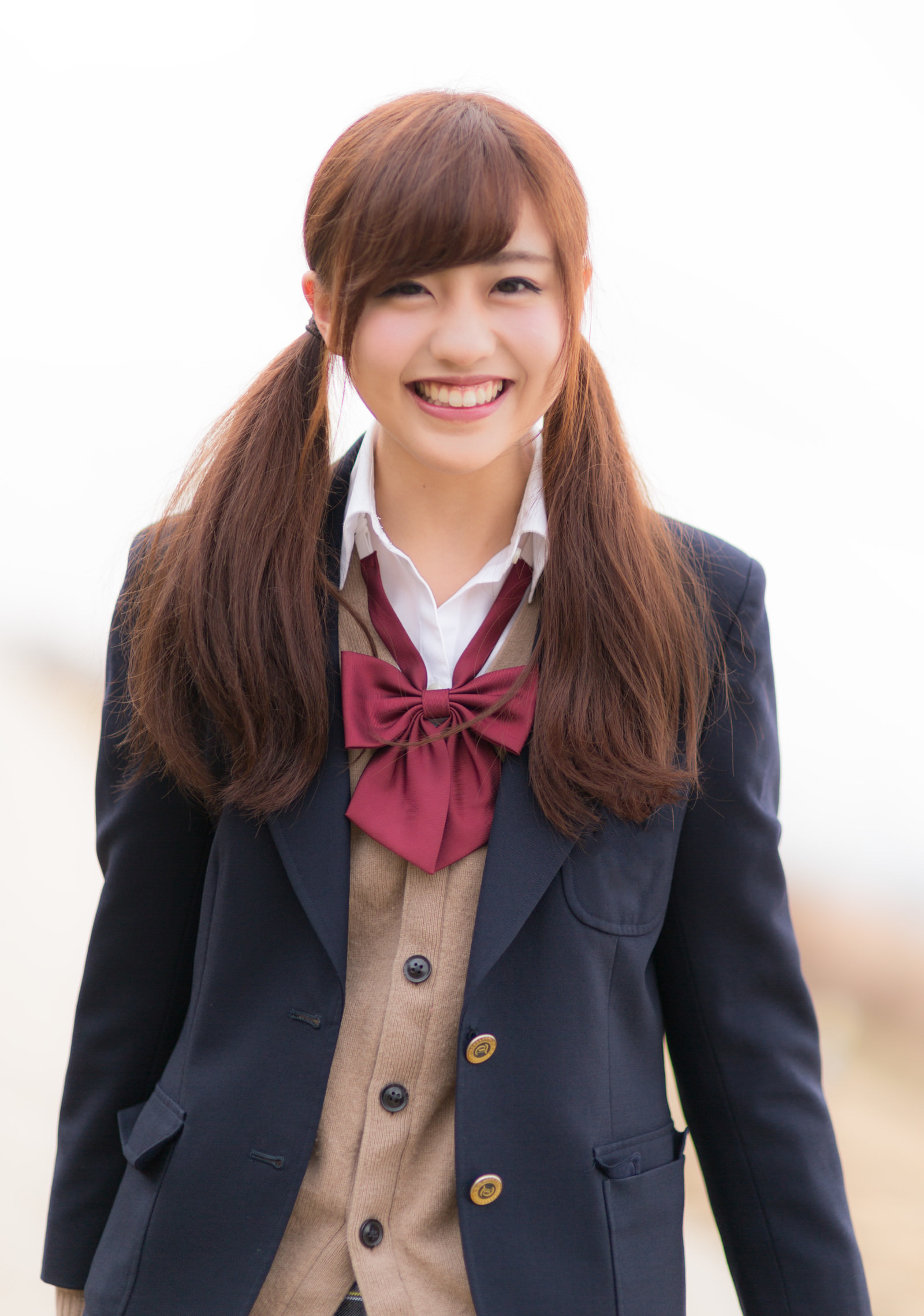 紺色の制服を着て笑顔を見せる女子生徒